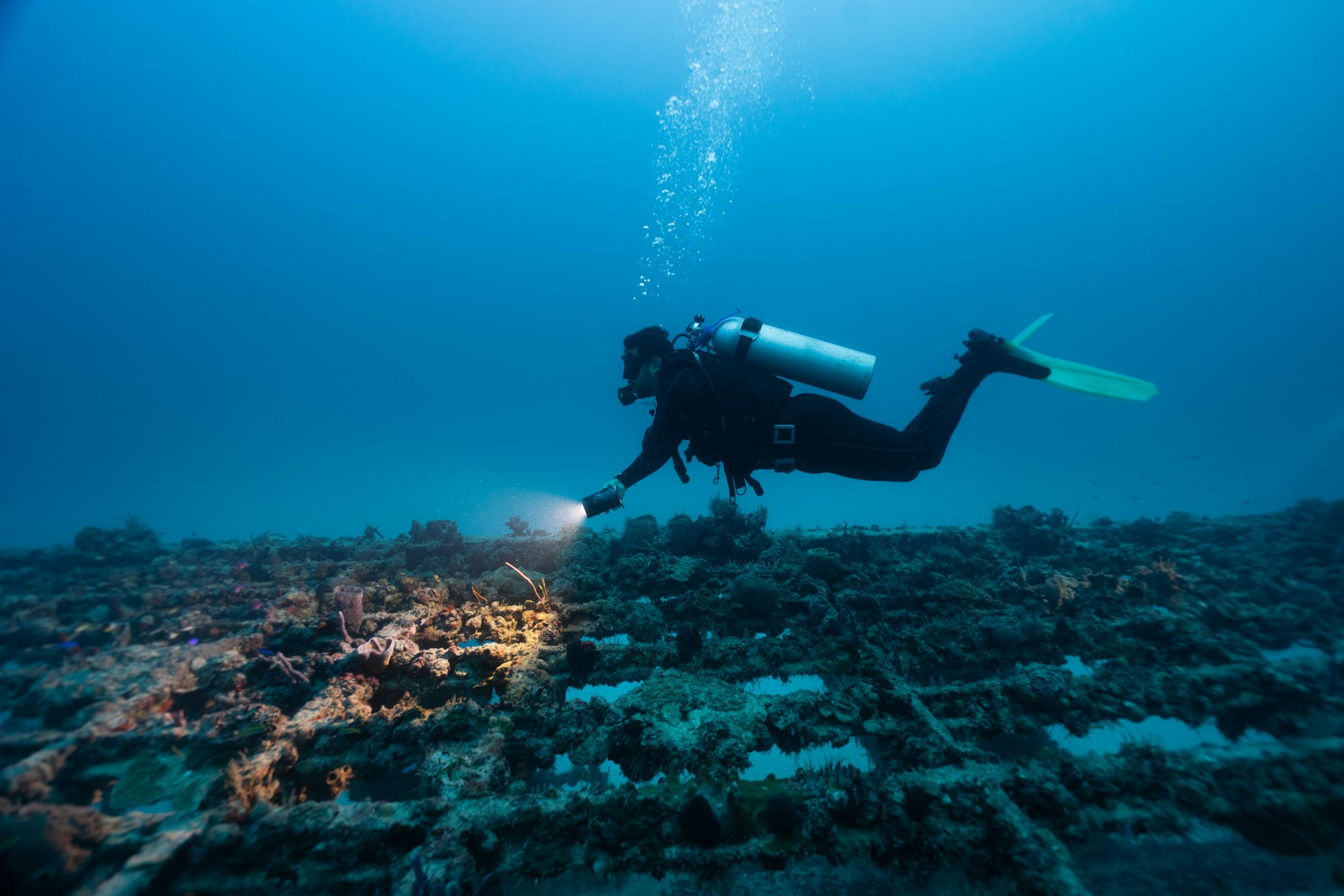 Diving instructor showing the difference in colors underwater. deep dive